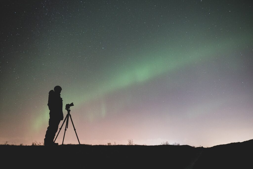 photographer silhouette northern lights